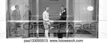 Business people standing by window, discussing, b&w, panoramic view View Large Photo Image Stock Image - Business people standing by window, discussing, b&w, panoramic view. Fotosearch