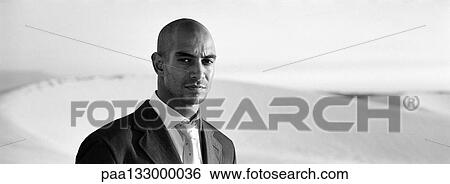 Businessman in front of dunes, b&w, panoramic view View Large Photo Image Stock Photograph - Businessman in front of dunes, b&w, panoramic view. Fotosearch