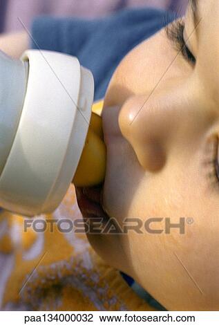 Stock Image - Baby drinking from bottle, close-up. Fotosearch