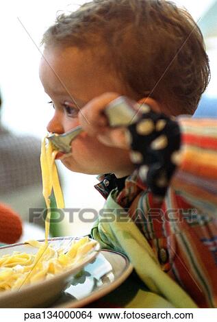Baby eating pasta, side view. View Large Photo Image Picture - Baby eating pasta, side view.. Fotosearch