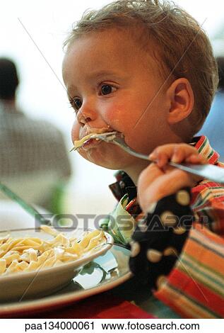 Baby, fork in mouth sideways and upside down, with bowl of pasta, head and shoulders, portrait. View Large Photo Image Stock Image - Baby, fork in mouth sideways and upside down, with bowl of pasta, head and shoulders, portrait.. Fotosearch
