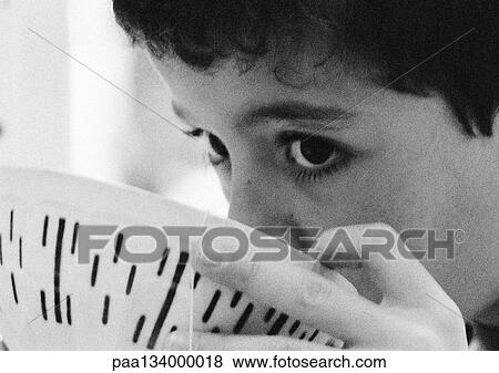 Stock Photo - Child drinking from bowl, close-up, b&w.. Fotosearch