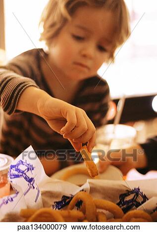 Child eating onion rings, blurred, portrait. View Large Photo Image Stock Photo - Child eating onion rings, blurred, portrait.. Fotosearch
