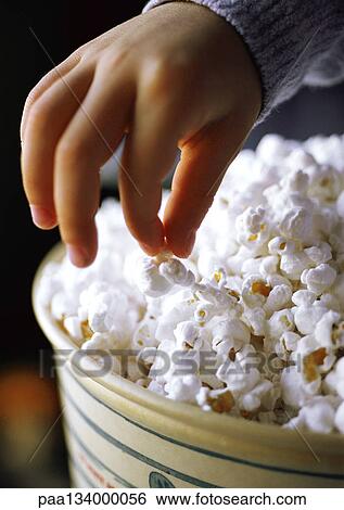 Child eating popcorn, close-up of hand and popcorn View Large Photo Image Stock Photograph - Child eating popcorn, close-up of hand and popcorn. Fotosearch