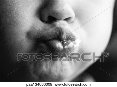 Stock Photo - Child puckering lips, close-up on mouth, b&w.. Fotosearch