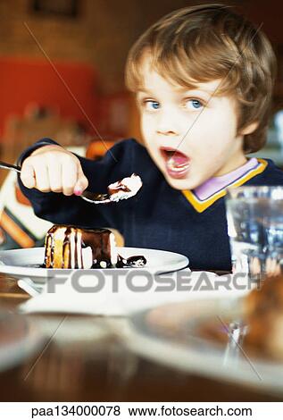 Little boy eating dessert, portrait. View Large Photo Image Stock Photo - Little boy eating dessert, portrait.. Fotosearch