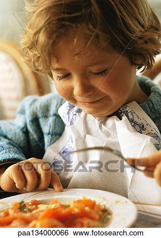 Little girl sitting at table, making face, portrait. View Large Photo Image Stock Photograph - Little girl sitting at table, making face, portrait.. Fotosearch