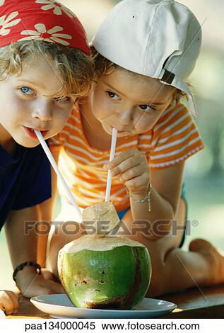 Two children drinking fresh juice through straws, close-up View Large Photo Image Stock Photography - Two children drinking fresh juice through straws, close-up. Fotosearch