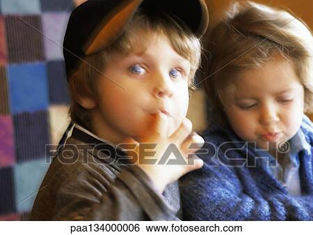 Two children, one looking into camera with finger in mouth, blurred. View Large Photo Image Stock Photograph - Two children, one looking into camera with finger in mouth, blurred.. Fotosearch