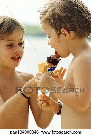 Stock Photograph - Two children sharing ice cream, portrait.. Fotosearch