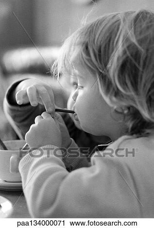 Stock Image - Two children sharing same straw, b&w.. Fotosearch
