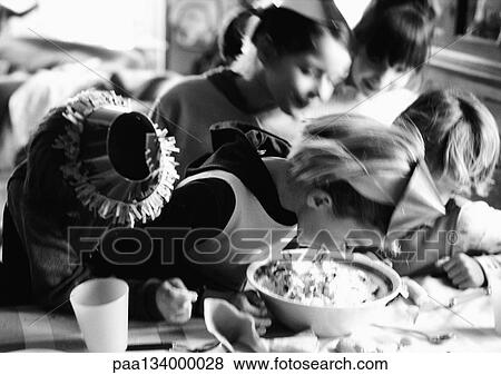Young children having party, heads down, b&w. View Large Photo Image Stock Photo - Young children having party, heads down, b&w.. Fotosearch