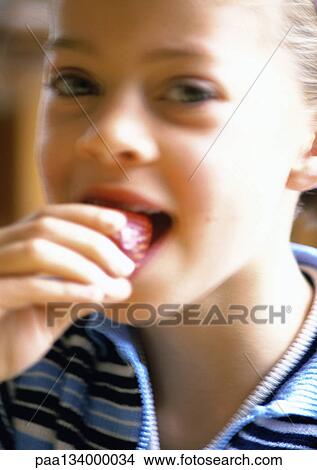 Young girl eating strawberry, portrait. View Large Photo Image Picture - Young girl eating strawberry, portrait.. Fotosearch