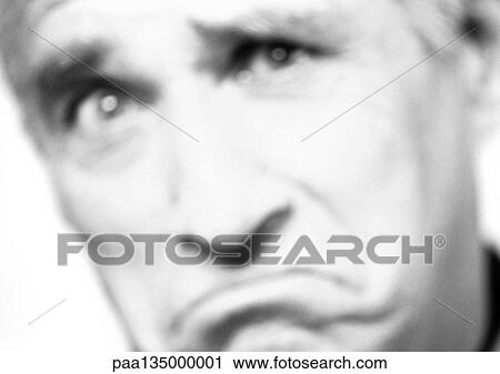 Stock Image - Mature man frowning, close-up, portrait, blurred, b&w. Fotosearch