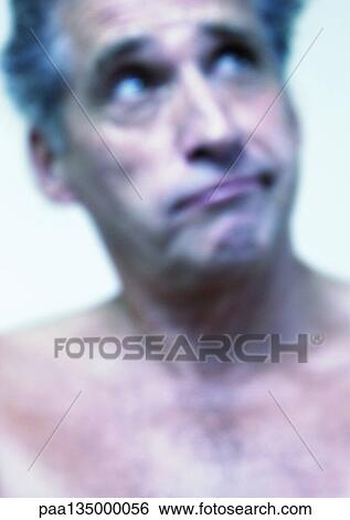 Stock Photograph - Mature man raising eyebrows, close-up, portrait, blurred. Fotosearch