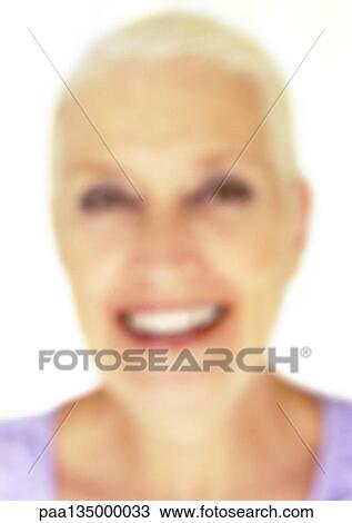 Stock Image - Mature woman smiling, close-up, portrait, blurred. Fotosearch