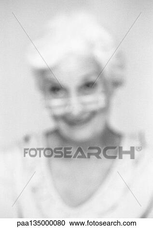 Senior woman looking over edge of glasses, close-up, portrait, blurred, b&w View Large Photo Image Stock Image - Senior woman looking over edge of glasses, close-up, portrait, blurred, b&w. Fotosearch