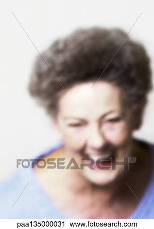Stock Image - Senior woman smiling, close-up, portrait, blurred. Fotosearch