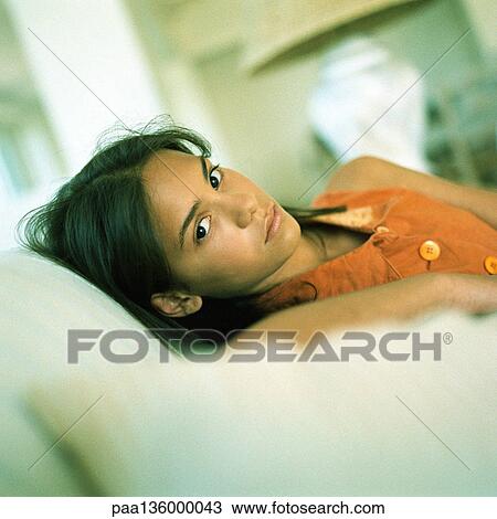 Stock Image - Girl sitting with head resting against back of chair, portrait. Fotosearch
