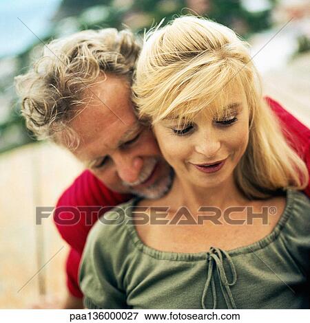 Stock Photo - Man standing behind woman, chin resting on her shoulder . Fotosearch