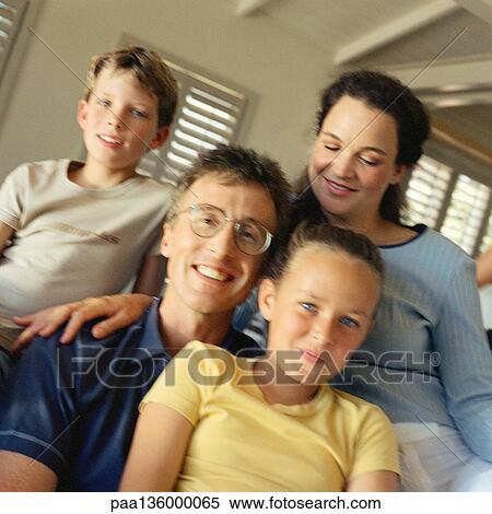 Stock Photography - Portrait of family all sitting closely together. Fotosearch