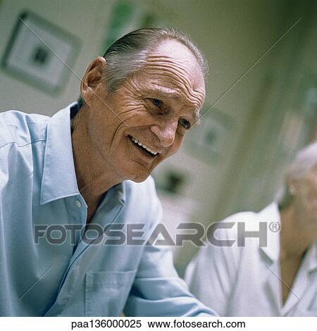 Stock Photography - Portrait of senior man, woman in background. Fotosearch
