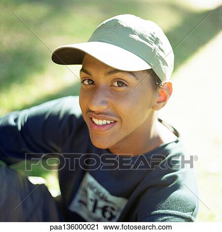 Stock Image - Portrait of teenage boy wearing hat and smiling. Fotosearch