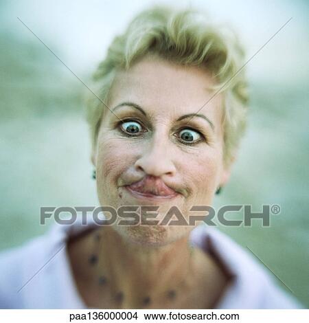 Portrait of woman with eyes crossed and tongue touching nose, close-up View Large Photo Image Picture - Portrait of woman with eyes crossed and tongue touching nose, close-up. Fotosearch