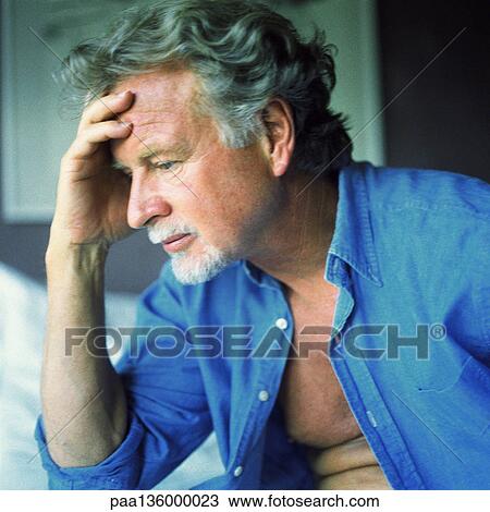 Stock Image - Profile of man with pensive expression and hand on forehead. Fotosearch