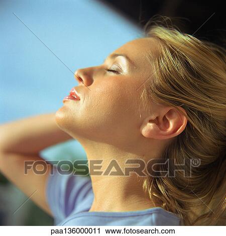 Stock Image - Profile of woman with head back and eyes shut. Fotosearch