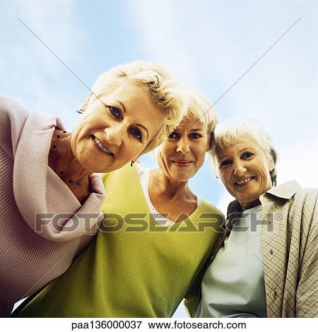 Three mature women, looking at camera, low angle view View Large Photo Image Stock Photo - Three mature women, looking at camera, low angle view. Fotosearch