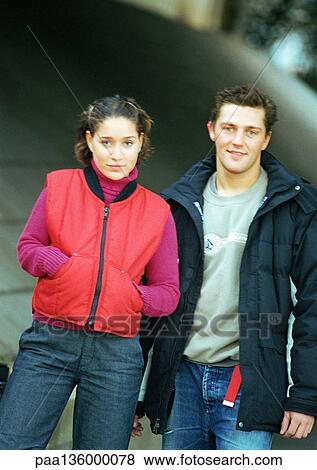 Young man and woman standing side by side wearing winter clothes View Large Photo Image Stock Photo - Young man and woman standing side by side wearing winter clothes. Fotosearch