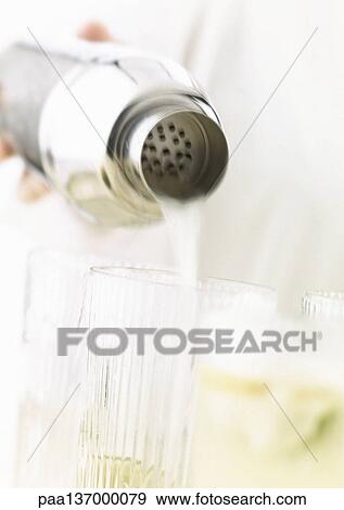 Stock Photo - Hand pouring cocktails, close-up.. Fotosearch