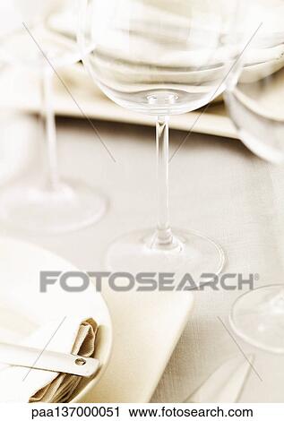 Stock Image - Table set with plates and glasses, close-up.. Fotosearch