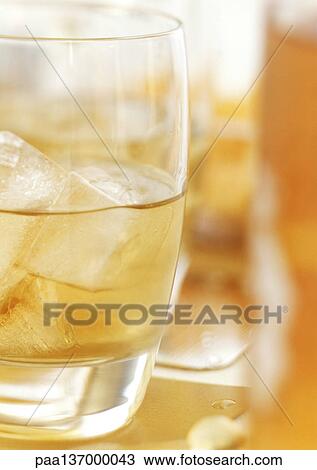 Whiskey on the rocks, close-up. View Large Photo Image Stock Image - Whiskey on the rocks, close-up.. Fotosearch