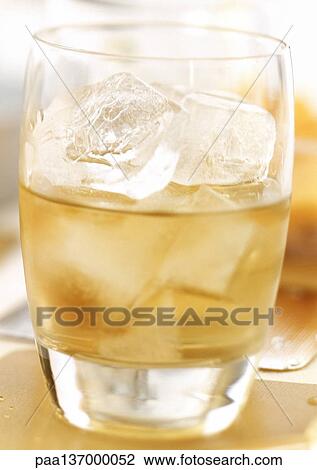 Stock Image - Whiskey with ice cubes.. Fotosearch