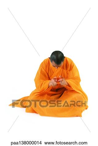 Picture - Buddhist monk meditating, holding scroll. Fotosearch