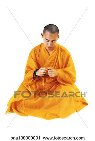 Buddhist monk sitting and meditating, holding prayer beads View Large Photo Image Stock Image - Buddhist monk sitting and meditating, holding prayer beads. Fotosearch