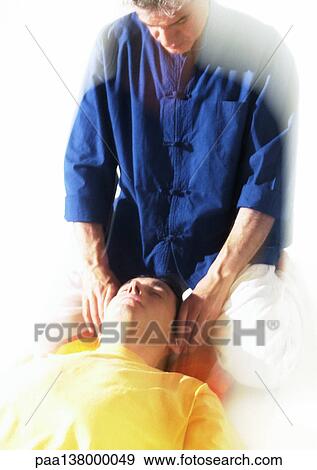 Massage therapist massaging man's head View Large Photo Image Stock Photo - Massage therapist massaging man's head. Fotosearch