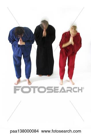 Three people standing, bending forward with hands together and eyes closed, blurred motion View Large Photo Image Picture - Three people standing, bending forward with hands together and eyes closed, blurred motion. Fotosearch