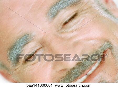 Stock Image - Mature man smiling, close-up, blurred. Fotosearch