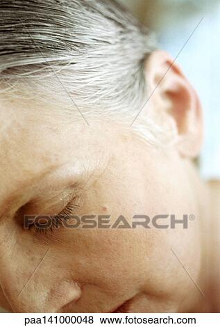 Stock Photo - Mature woman, eyes closed, partial view of face, close-up.. Fotosearch