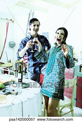 Couple clinking wine glasses, laughing. View Large Photo Image Stock Photo - Couple clinking wine glasses, laughing.. Fotosearch