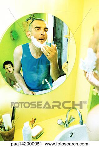 Two men in bathroom, one shaving, one in tub, reflection in mirror. View Large Photo Image Stock Image - Two men in bathroom, one shaving, one in tub, reflection in mirror.. Fotosearch