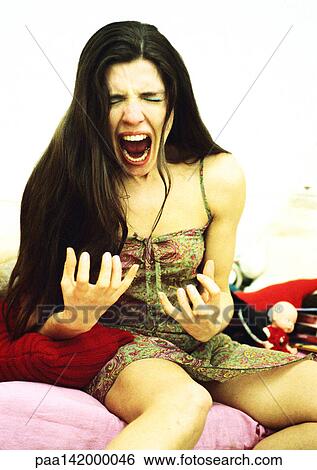 Woman sitting on bed screaming, portrait. View Large Photo Image Stock Photograph - Woman sitting on bed screaming, portrait.. Fotosearch
