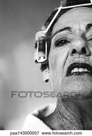 Elderly woman in hair rollers sneering, partial low angle view, close-up, b&w View Large Photo Image Stock Photo - Elderly woman in hair rollers sneering, partial low angle view, close-up, b&w. Fotosearch