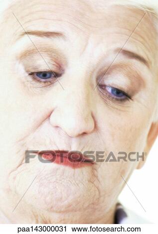 Stock Image - Elderly woman looking down, portrait, close-up. Fotosearch