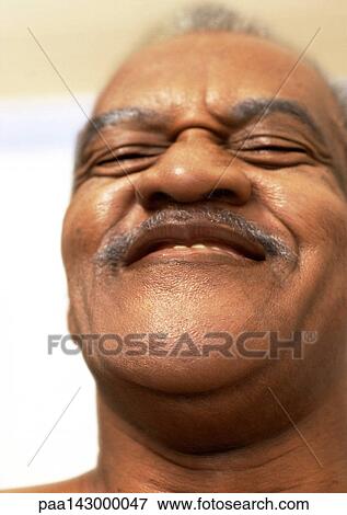 Stock Photo - Mature man smiling, portrait, close-up, low angle view. Fotosearch