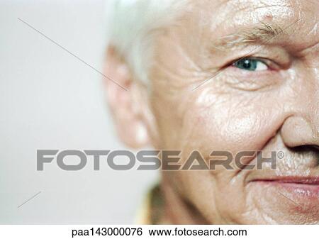 Stock Photograph - Senior man looking at camera, close-up, partial view. Fotosearch