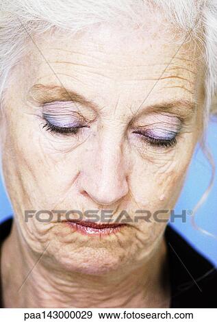 Senior woman looking down and pursing lips, portrait, close-up View Large Photo Image Stock Photo - Senior woman looking down and pursing lips, portrait, close-up. Fotosearch